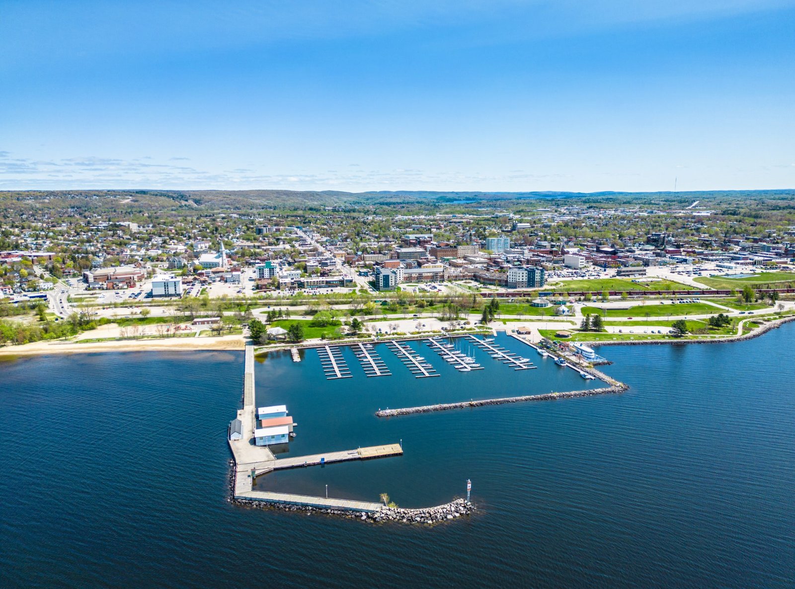 Aerial view of the North Bay marina, beach and waterfront park with the downtown skyline behind